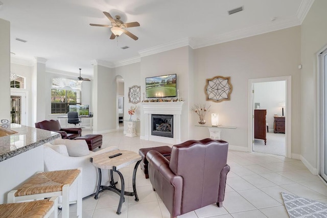 359 Indigo Loop, Miramar Beach, FL 32550 - living area with a ceiling fan, light tile patterned floors, ornamental molding, a glass covered fireplace, and arched walkways