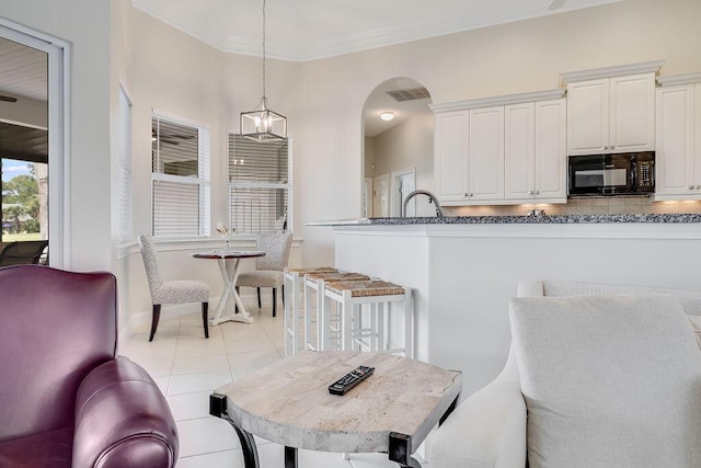 359 Indigo Loop, Miramar Beach, FL 32550 - dining space with ornamental molding, light tile patterned floors, baseboards, a chandelier, and arched walkways