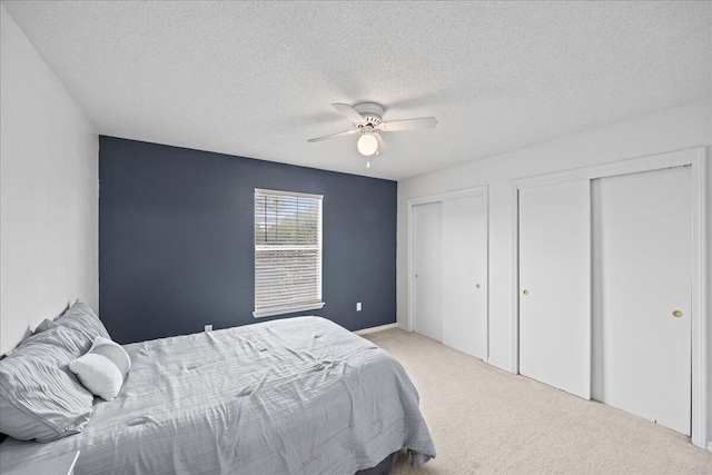 1176 Lost Trl, Fort Walton Beach, FL 32547 - carpeted bedroom with two closets, a textured ceiling, and a ceiling fan