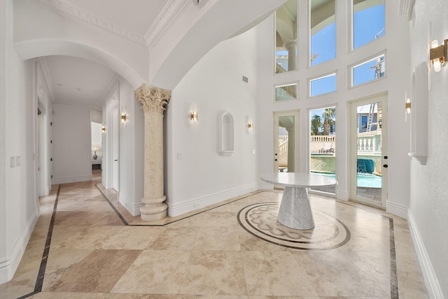 30 Pelican Cir, Inlet Beach, FL 32461 - entryway featuring crown molding, baseboards, decorative columns, inlaid floor details, and arched walkways