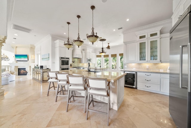 30 Pelican Cir, Inlet Beach, FL 32461 - kitchen featuring built in appliances, beverage cooler, ornamental molding, tasteful backsplash, and white cabinetry