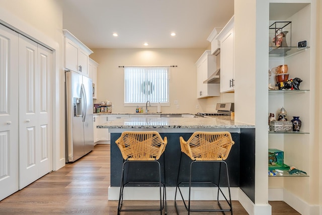 409 Hideaway Ln, Niceville, FL 32578 - kitchen featuring stainless steel fridge with ice dispenser, range, a peninsula, white cabinets, and light stone countertops
