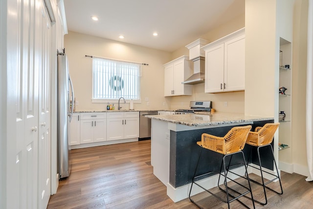 409 Hideaway Ln, Niceville, FL 32578 - kitchen with appliances with stainless steel finishes, a peninsula, light wood-style floors, light stone counters, and white cabinets