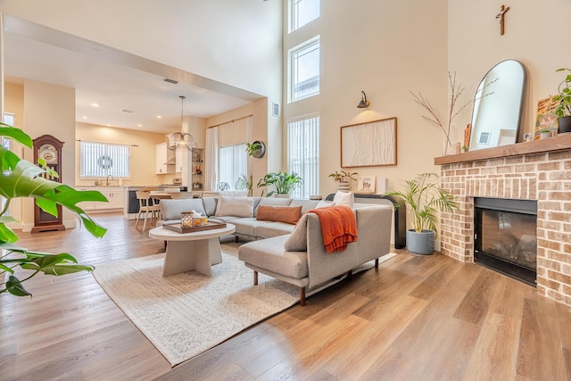 409 Hideaway Ln, Niceville, FL 32578 - living room with light wood-style flooring, a brick fireplace, and a towering ceiling