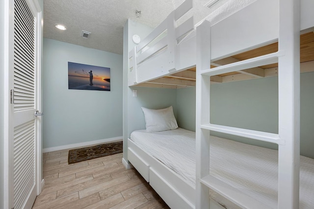 1515 SE Miracle Strip Pkwy Unit 613, Fort Walton Beach, FL 32548 - bedroom with wood finished floors, baseboards, and a textured ceiling