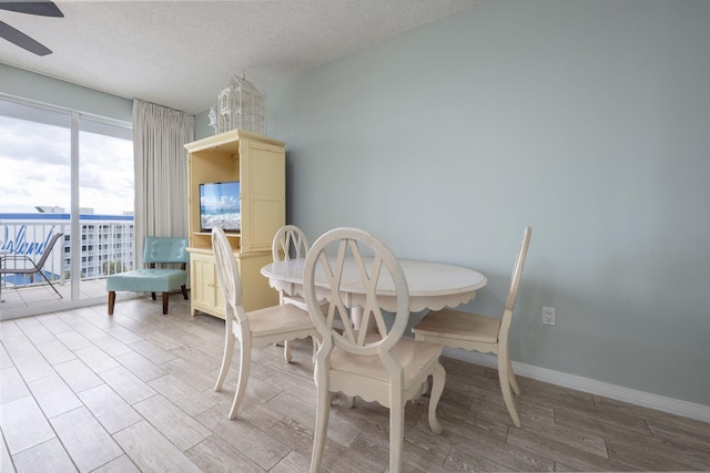 1515 SE Miracle Strip Pkwy Unit 613, Fort Walton Beach, FL 32548 - dining area featuring wood finished floors, a ceiling fan, a textured ceiling, and baseboards