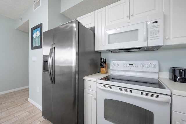 1515 SE Miracle Strip Pkwy Unit 613, Fort Walton Beach, FL 32548 - kitchen featuring white appliances, light wood-style floors, light countertops, white cabinets, and baseboards