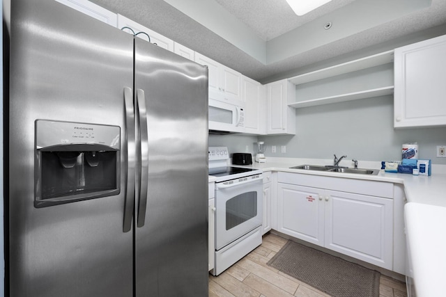 1515 SE Miracle Strip Pkwy Unit 613, Fort Walton Beach, FL 32548 - kitchen featuring white appliances, a sink, open shelves, light wood finished floors, and white cabinets