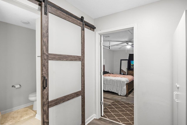 4887 Martina Way, Gulf Breeze, FL 32563 - bathroom with connected bathroom, toilet, a textured ceiling, baseboards, and a ceiling fan