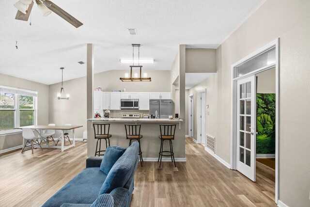 4887 Martina Way, Gulf Breeze, FL 32563 - living area featuring a chandelier, light wood-style floors, lofted ceiling, baseboards, and a ceiling fan