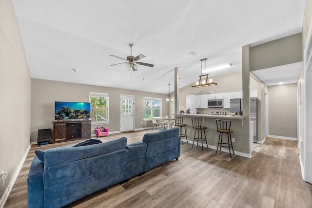 4887 Martina Way, Gulf Breeze, FL 32563 - living area with lofted ceiling, light wood-style flooring, baseboards, a textured ceiling, and ceiling fan