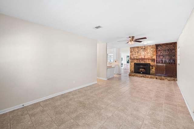 814 Tuxedo Dr, Fort Walton Beach, FL 32547 - unfurnished living room featuring a ceiling fan, baseboards, a stone fireplace, and light tile patterned flooring