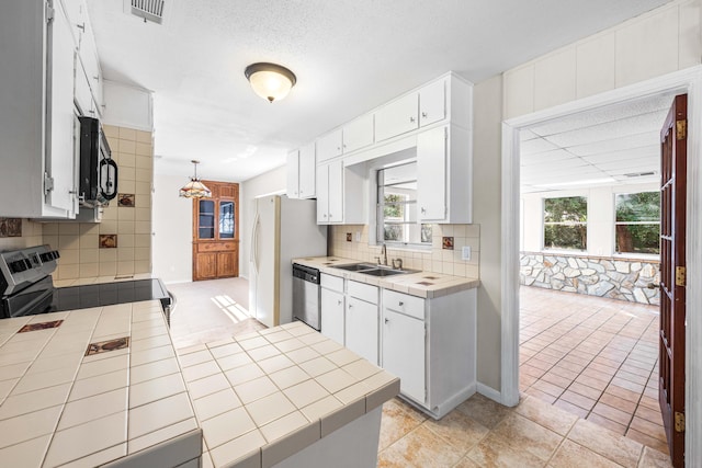 814 Tuxedo Dr, Fort Walton Beach, FL 32547 - kitchen with tile counters, appliances with stainless steel finishes, a sink, and tasteful backsplash