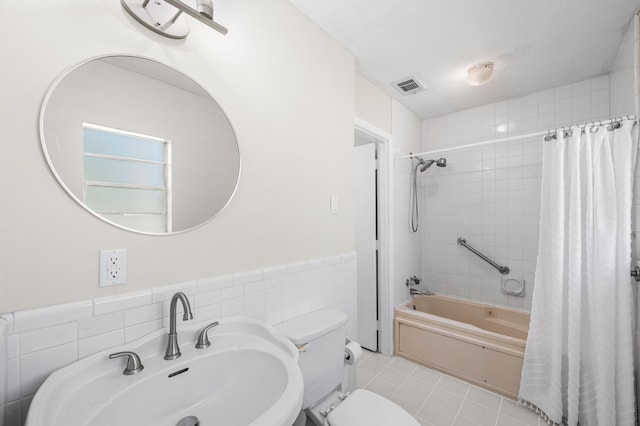 814 Tuxedo Dr, Fort Walton Beach, FL 32547 - bathroom featuring shower / bathtub combination with curtain, toilet, a sink, tile walls, and wainscoting