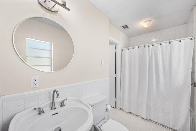 814 Tuxedo Dr, Fort Walton Beach, FL 32547 - full bath with toilet, tile walls, a sink, a wainscoted wall, and tile patterned flooring