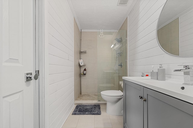 1190 Witshire Ct, Fort Walton Beach, FL 32547 - bathroom featuring vanity, toilet, tile patterned flooring, wooden walls, and tiled shower