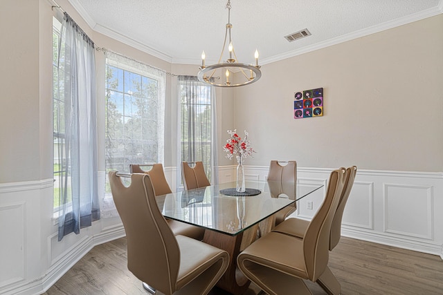 1190 Witshire Ct, Fort Walton Beach, FL 32547 - dining room featuring a chandelier, wood finished floors, wainscoting, a textured ceiling, and ornamental molding