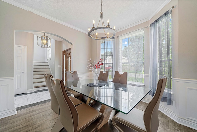 1190 Witshire Ct, Fort Walton Beach, FL 32547 - dining area with a chandelier, arched walkways, a wainscoted wall, stairs, and a textured ceiling