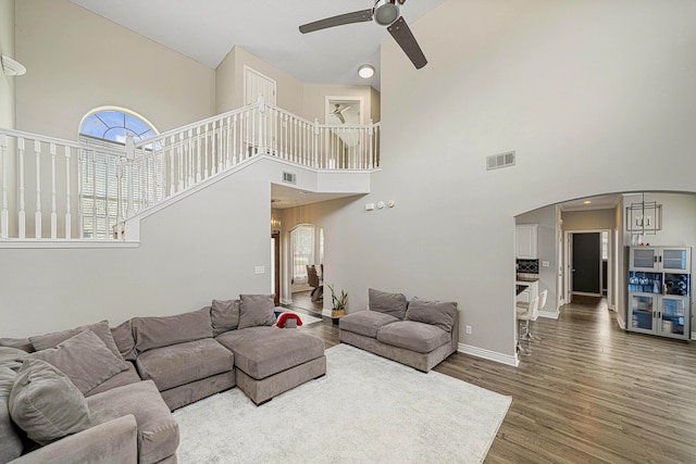 1190 Witshire Ct, Fort Walton Beach, FL 32547 - living area featuring arched walkways, a ceiling fan, a high ceiling, wood finished floors, and healthy amount of natural light