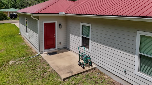 148 Engelbrecht Rd, Defuniak Springs, FL 32433 - property entrance with a yard, a patio, and metal roof