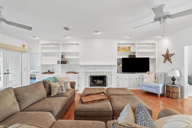84 Old Miller Pl, Santa Rosa Beach, FL 32459 - living room featuring a ceiling fan, light wood-type flooring, a fireplace, and built in features