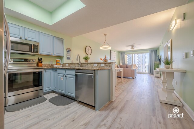 112 Seascape Dr Unit 704, Miramar Beach, FL 32550 - kitchen featuring appliances with stainless steel finishes, a peninsula, light wood finished floors, and open floor plan