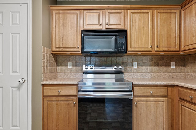 138 Conquest Ave, Crestview, FL 32536 - kitchen with stainless steel range with electric cooktop, black microwave, tasteful backsplash, and light countertops