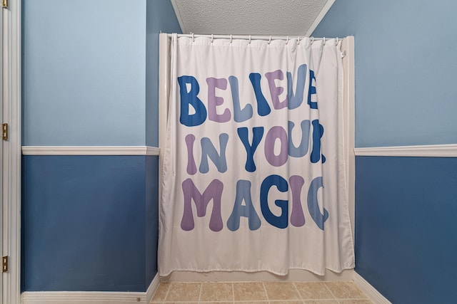 138 Conquest Ave, Crestview, FL 32536 - bathroom featuring a textured ceiling, curtained shower, and baseboards