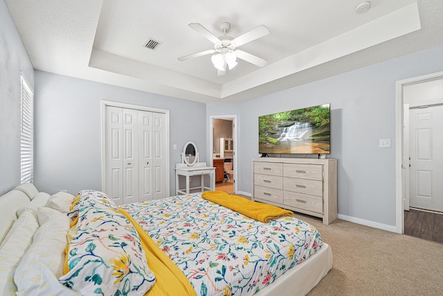 138 Conquest Ave, Crestview, FL 32536 - bedroom featuring a tray ceiling, a closet, carpet, a ceiling fan, and baseboards