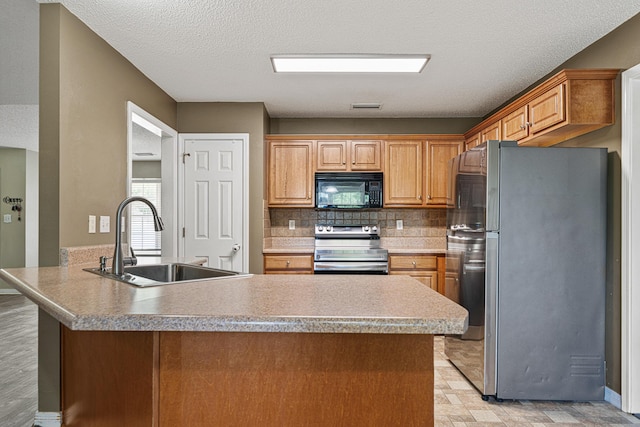138 Conquest Ave, Crestview, FL 32536 - kitchen with appliances with stainless steel finishes, a sink, a peninsula, decorative backsplash, and a textured ceiling