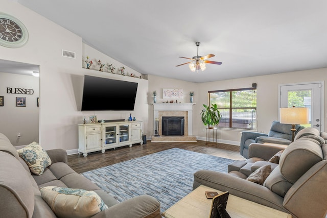 7302 Manatee St, Navarre, FL 32566 - living area featuring baseboards, dark wood-style flooring, a ceiling fan, vaulted ceiling, and a fireplace with raised hearth