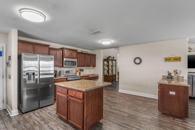 7302 Manatee St, Navarre, FL 32566 - kitchen featuring appliances with stainless steel finishes, baseboards, dark wood-style flooring, and light stone counters