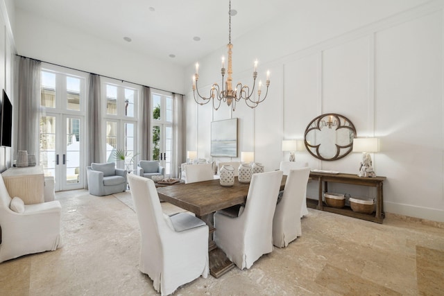 132 N Somerset St, Alys Beach, FL 32461 - dining room featuring a chandelier, a high ceiling, french doors, and a decorative wall