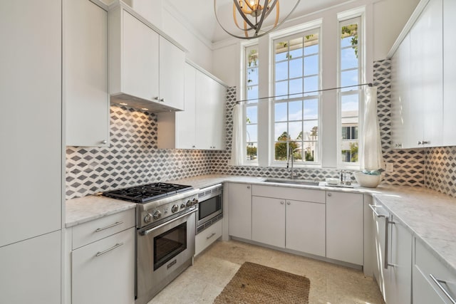 132 N Somerset St, Alys Beach, FL 32461 - kitchen featuring stainless steel appliances, tasteful backsplash, a sink, and light stone countertops