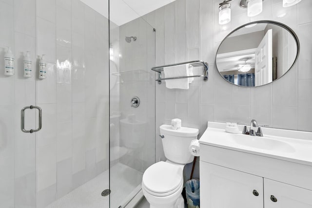 144 Spires Ln Unit 202, Santa Rosa Beach, FL 32459 - full bathroom featuring tile walls, vanity, a shower stall, and toilet