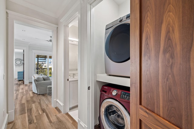 89 Shirah St, Destin, FL 32541 - laundry room with stacked washer / drying machine, light wood finished floors, baseboards, ornamental molding, and a ceiling fan