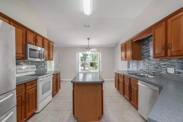 1184 Blackberry Cir, Baker, FL 32531 - kitchen featuring appliances with stainless steel finishes, a sink, a center island, backsplash, and ceiling fan
