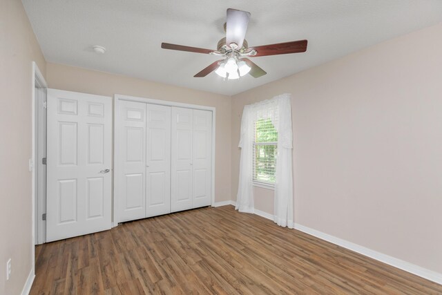 1184 Blackberry Cir, Baker, FL 32531 - unfurnished bedroom with baseboards, wood finished floors, a closet, and a ceiling fan