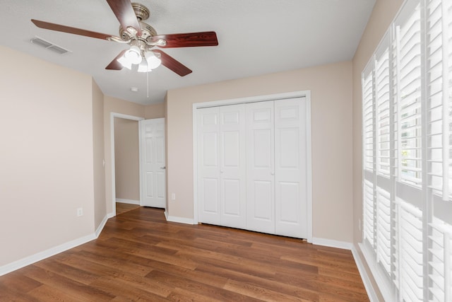 1184 Blackberry Cir, Baker, FL 32531 - unfurnished bedroom with multiple windows, wood finished floors, and baseboards
