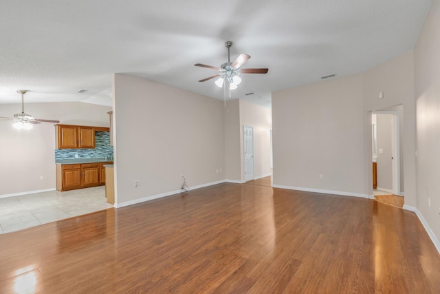 1184 Blackberry Cir, Baker, FL 32531 - unfurnished living room featuring a ceiling fan, vaulted ceiling, light wood-type flooring, and baseboards