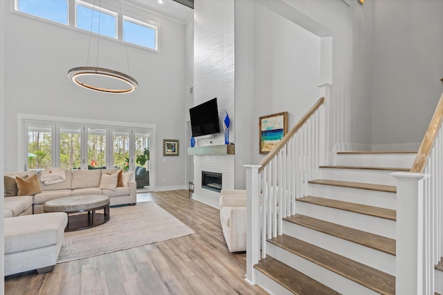 276 W Lafayette Rd, Inlet Beach, FL 32461 - living area with a high ceiling, stairway, a large fireplace, wood finished floors, and baseboards
