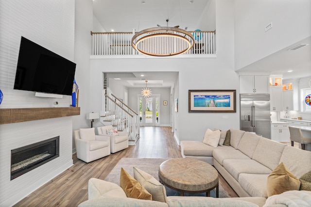 276 W Lafayette Rd, Inlet Beach, FL 32461 - living room featuring a towering ceiling, light wood-style floors, a glass covered fireplace, baseboards, and stairway