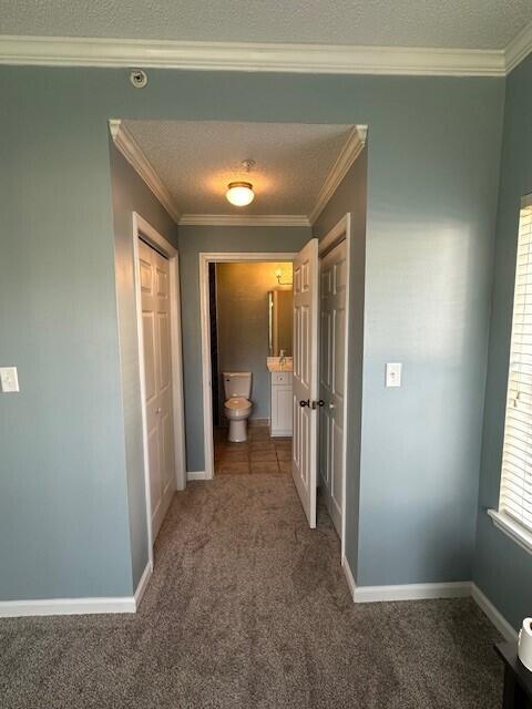 200 Sandestin Ln Apt 401, Miramar Beach, FL 32550 - hallway with carpet floors, ornamental molding, baseboards, and a textured ceiling