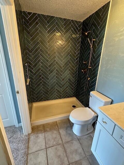 200 Sandestin Ln Apt 401, Miramar Beach, FL 32550 - full bath with a textured ceiling, toilet, vanity, tile patterned flooring, and a shower stall