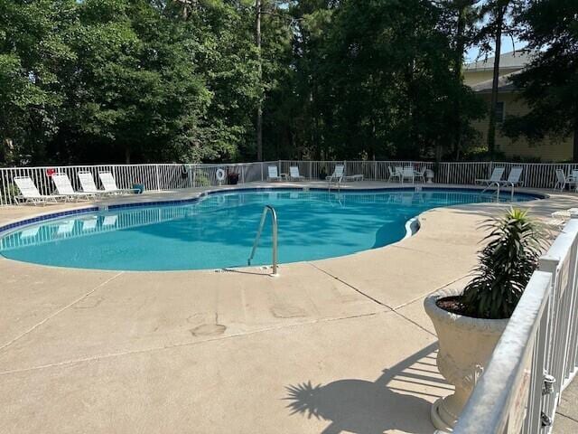 200 Sandestin Ln Apt 401, Miramar Beach, FL 32550 - community pool with a patio area and view of wooded area