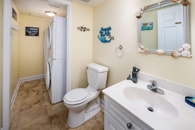 660 Nautilus Ct Unit 1103, Fort Walton Beach, FL 32548 - bathroom featuring stacked washer / dryer, toilet, vanity, and baseboards