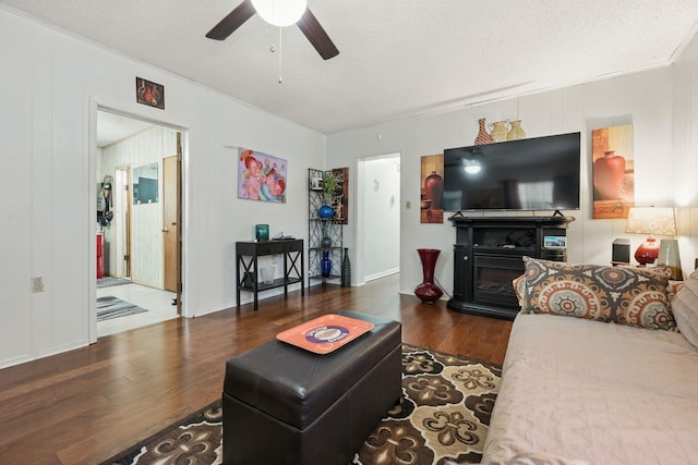 101 SE Elm Ave, Fort Walton Beach, FL 32548 - living room featuring wood finished floors, a ceiling fan, a textured ceiling, and a glass covered fireplace
