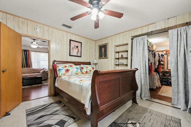 101 SE Elm Ave, Fort Walton Beach, FL 32548 - bedroom featuring wooden walls, crown molding, a textured ceiling, a closet, and a spacious closet