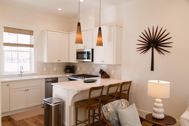 250 Beach Bike Way, Inlet Beach, FL 32461 - kitchen featuring stainless steel appliances, a sink, backsplash, a breakfast bar, and light countertops