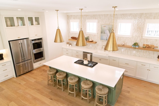 250 Beach Bike Way, Inlet Beach, FL 32461 - kitchen featuring stainless steel appliances, white cabinetry, a sink, a breakfast bar area, and light wood finished floors
